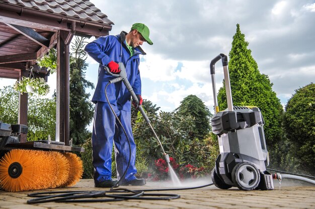 mage of a person using a high power pressure washer rental to clean a driveway efficiently.